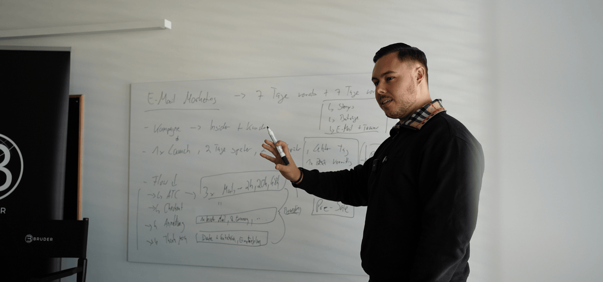 Foto einer Unterrichtsszene vor einem Whiteboard mit skizzierten Konzepten, symbolisiert die Verbindung aus kreativer Arbeit und datenbasierter Auswertung